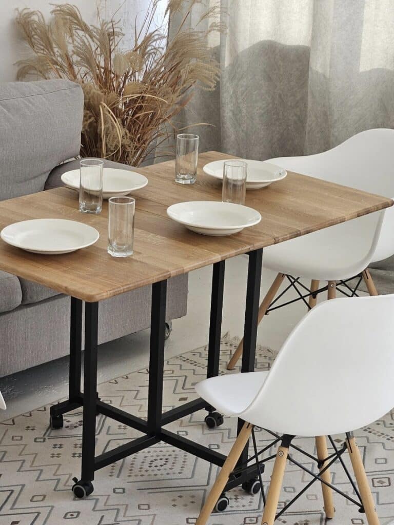 Small dining room ideas: oak folding table on wheels set up for four in a compact living-dining space.