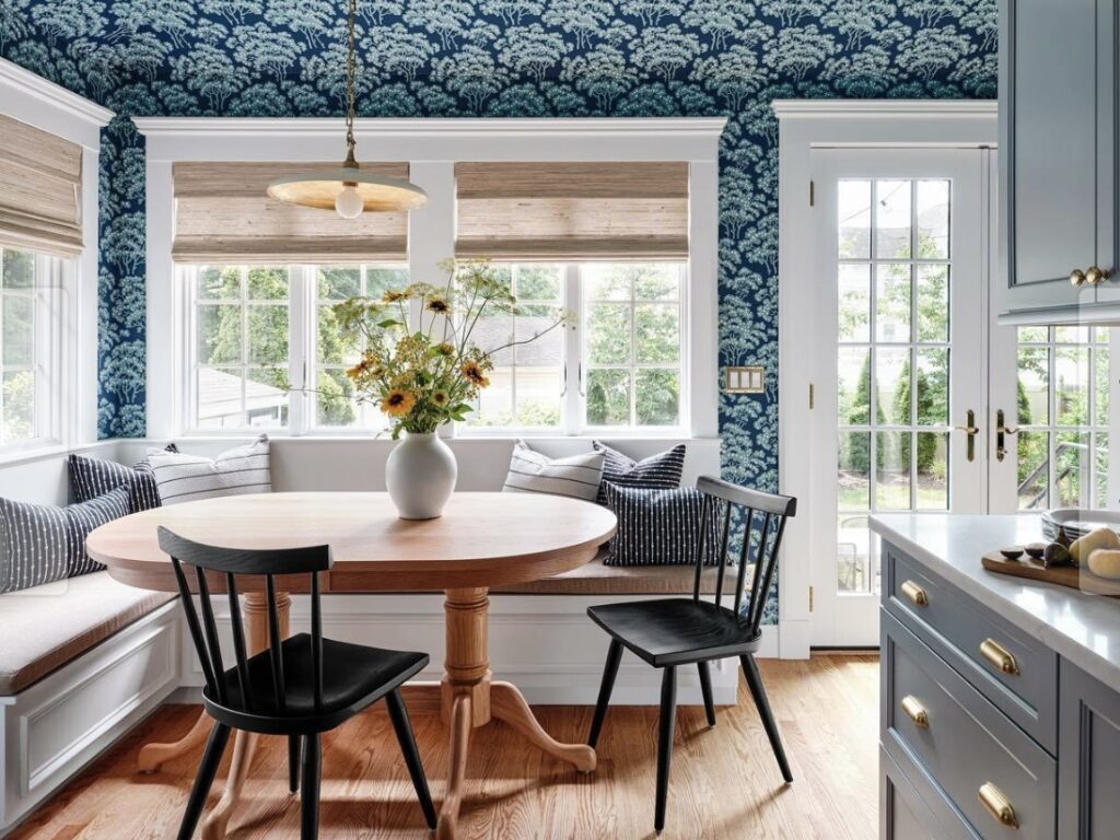 Small dining room ideas featuring Farrow & Ball Hornbeam wallpaper with built-in bench seating and a round oak table in a compact kitchen-diner.