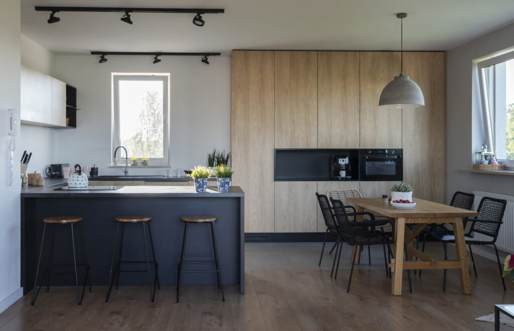 Small dining room ideas in a modern kitchen-diner with a kitchen breakfast bar, black island stools, and a compact dining table.