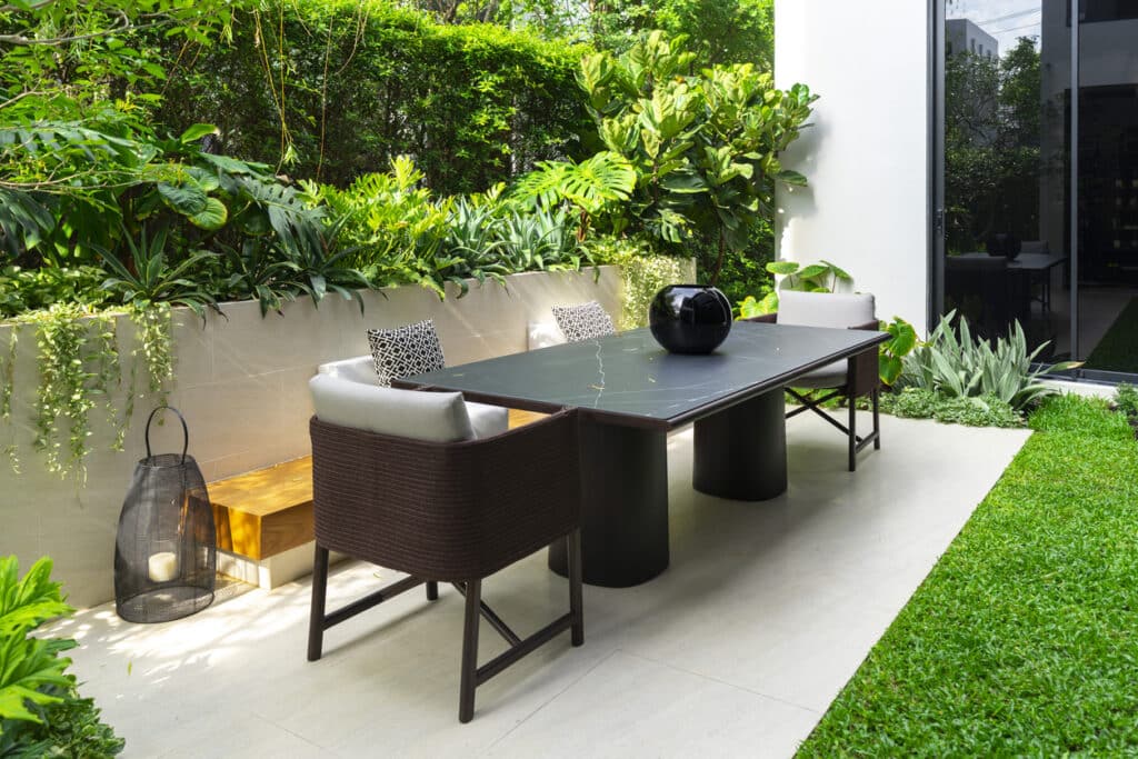 Small garden ideas: modern patio with compact garden furniture and lush planting