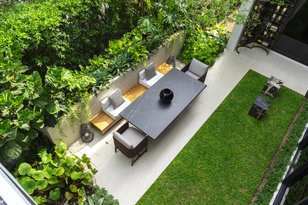 Small garden ideas UK: zoning a compact garden with patio, lawn and boundary planting