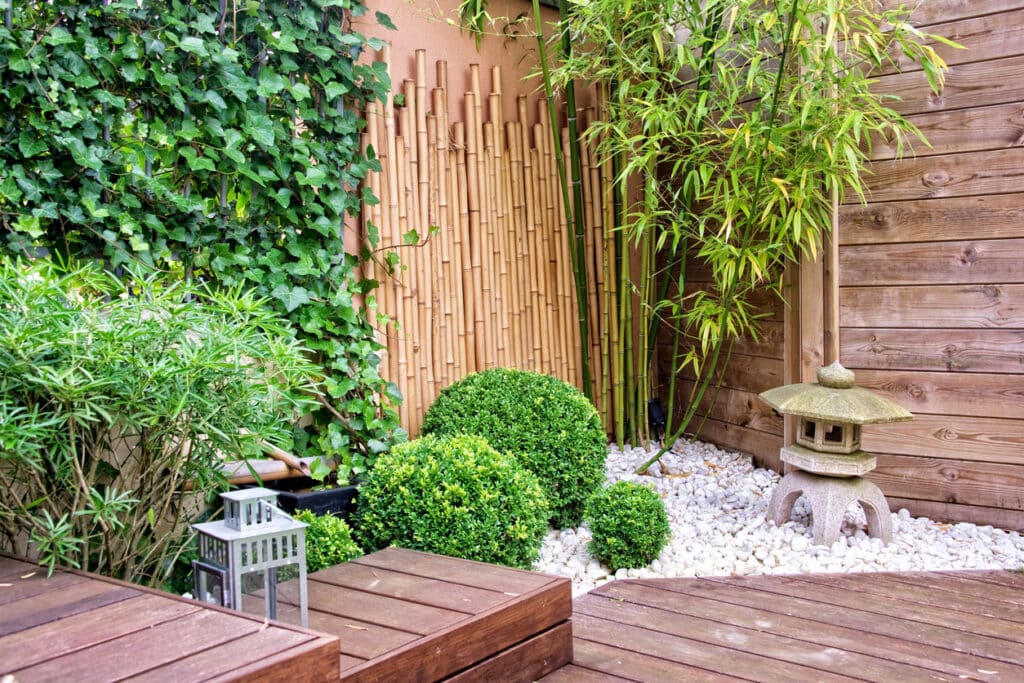 Small garden ideas: bamboo screening, gravel planting and timber decking creating a calm courtyard garden corner