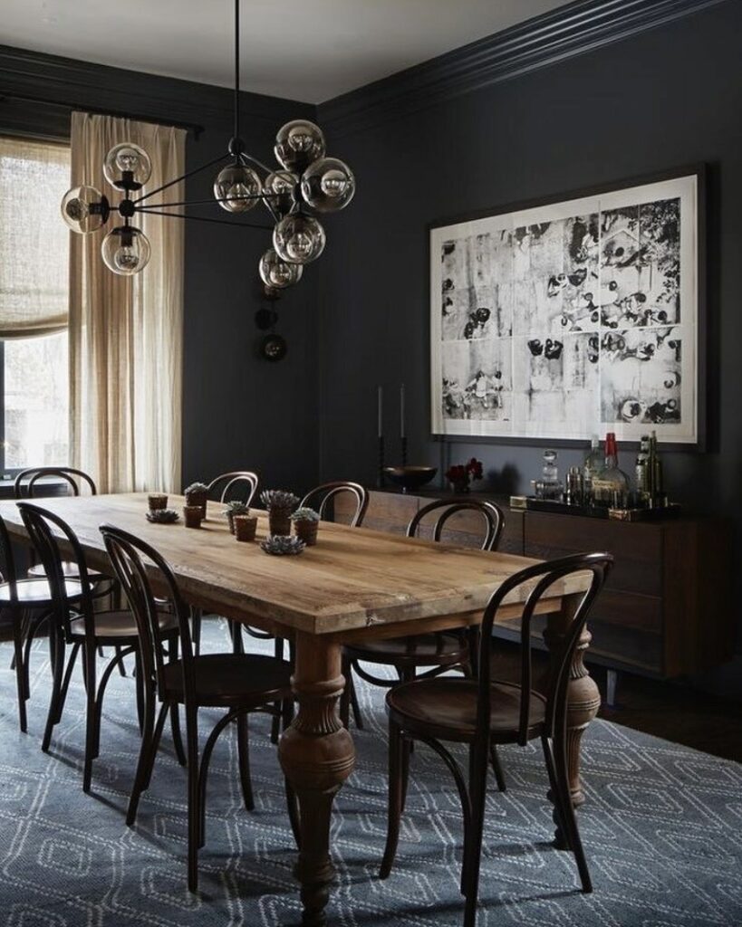 dark dining room colour ideas with down pipe walls large wooden table and statement pendant lighting