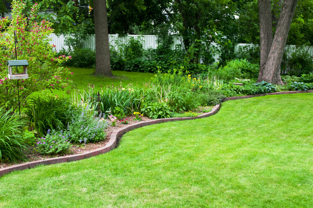 curved brick garden edging between lawn and planted border