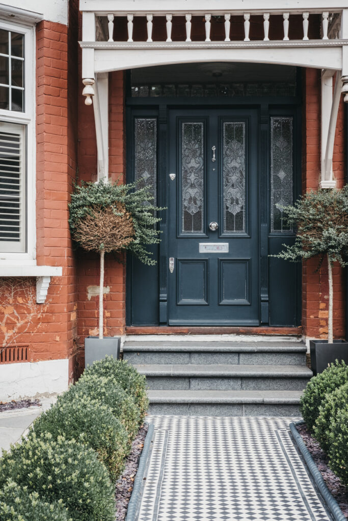 front garden edging with low border and clipped shrubs along a tiled entrance path