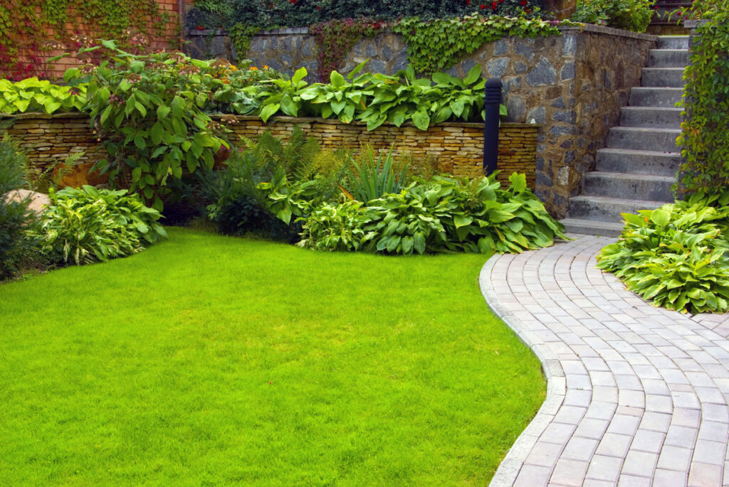 curved stone garden path edging separating lawn from planting borders