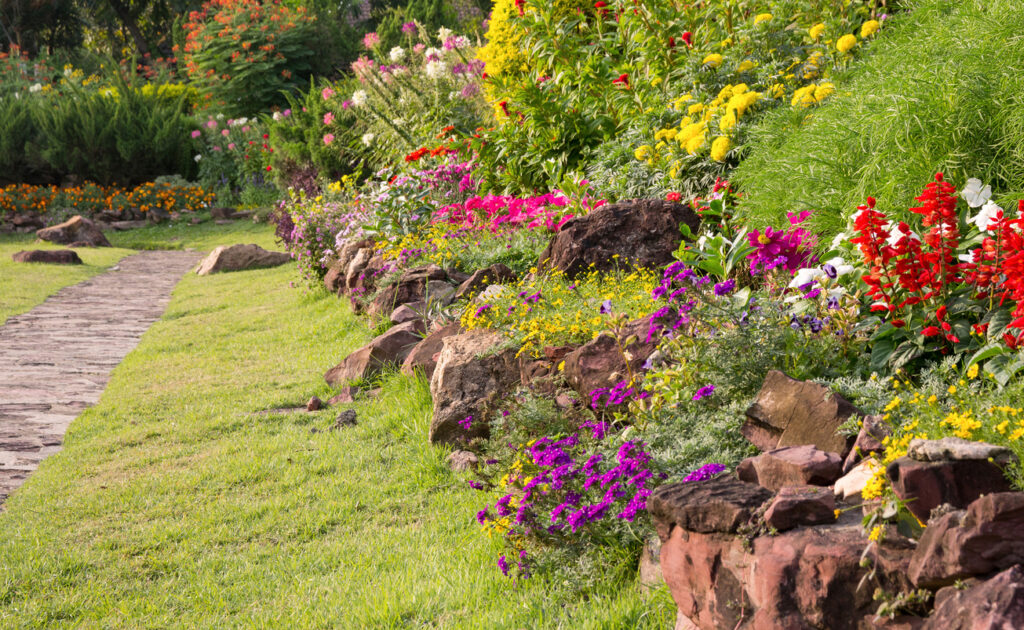 stone garden edging along curved flower border beside lawn and pathway