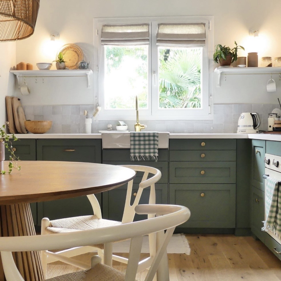 Kitchen diner with Green Smoke lower cabinets, Strong White walls, open shelving and a round wooden dining table