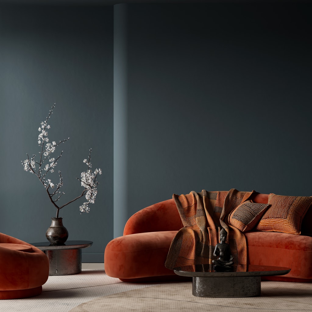 Burnt orange curved sofa in a modern orange living room with deep blue walls, neutral rug and minimalist Japandi styling