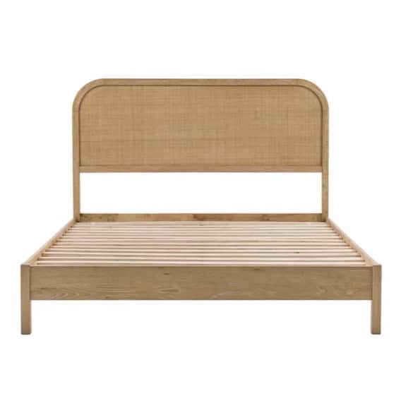 Curved wood and rattan bed creating a chic boho beige bedroom