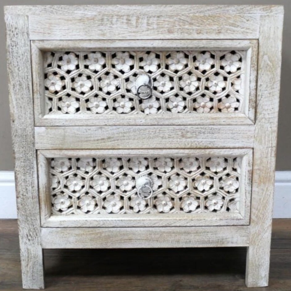 White-washed carved bedside table in a chic boho beige bedroom