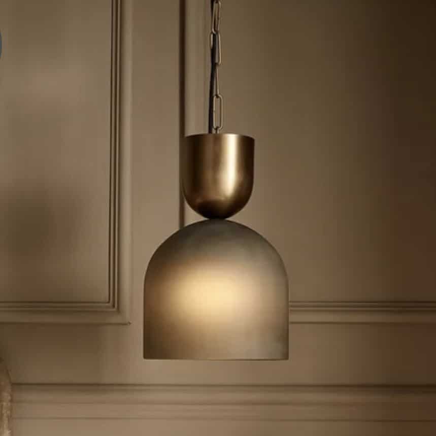 Frosted glass pendant light above a bedside table in a beige bedroom
