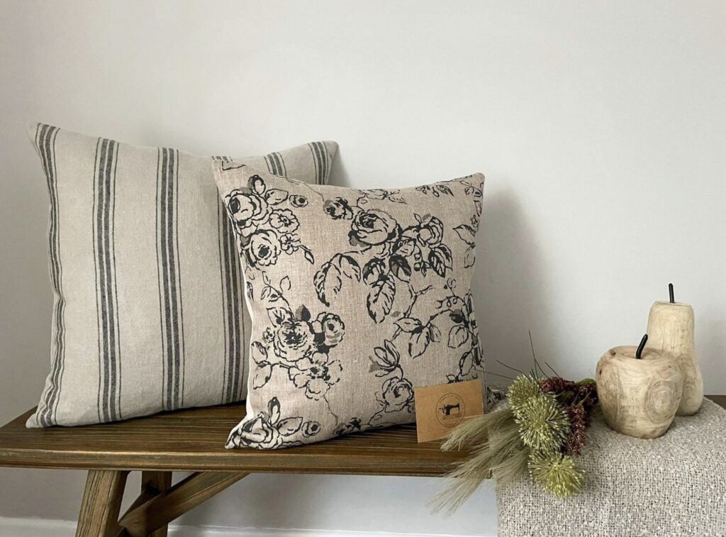 Black and beige striped and floral cushions styled together to show how to mix patterns in a neutral scheme