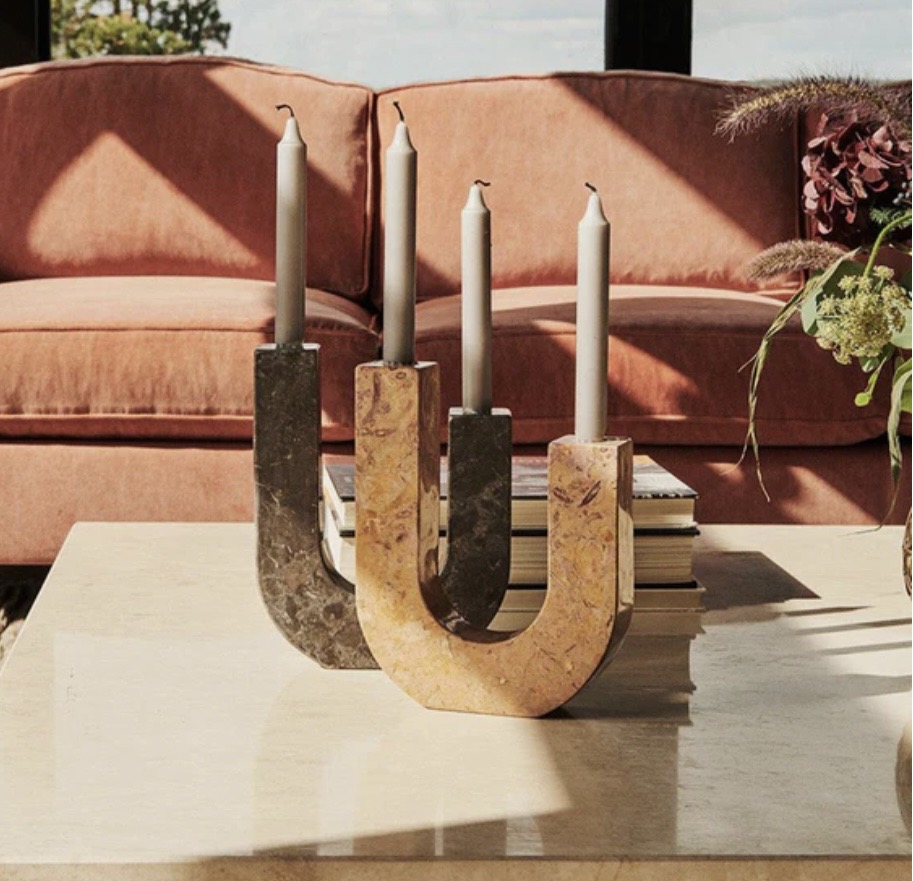 Dusty Deco Arco Candle Holder styled on a coffee table in front of a warm-toned sofa, showing sculptural candle holders as part of coffee table décor.