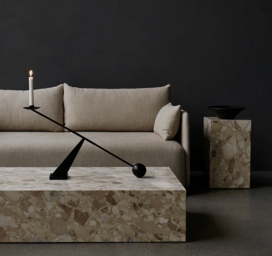 Audo Copenhagen Interconnect Candle Holder in black styled on a stone coffee table in a black living room, showing sculptural coffee table décor ideas.