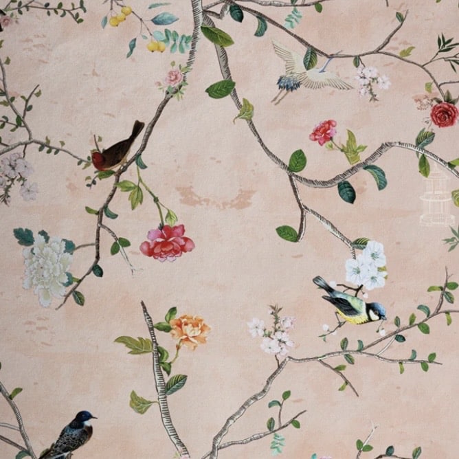 Watermelon blush chinoiserie wallpaper with birds and blossom branches creating a romantic pink and green bedroom
