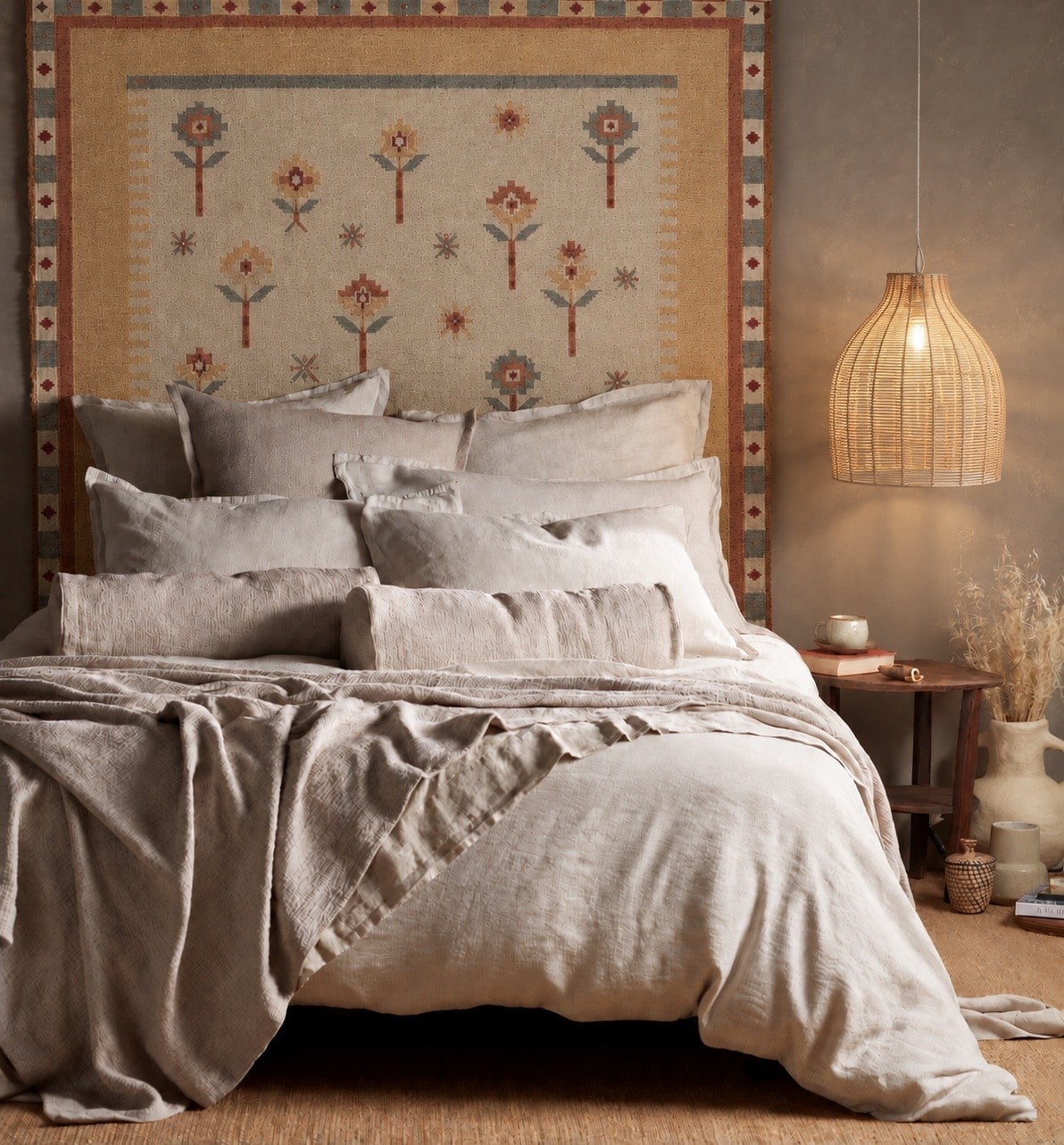 Boho beige bedroom with feather grass wallpaper and a cane bed