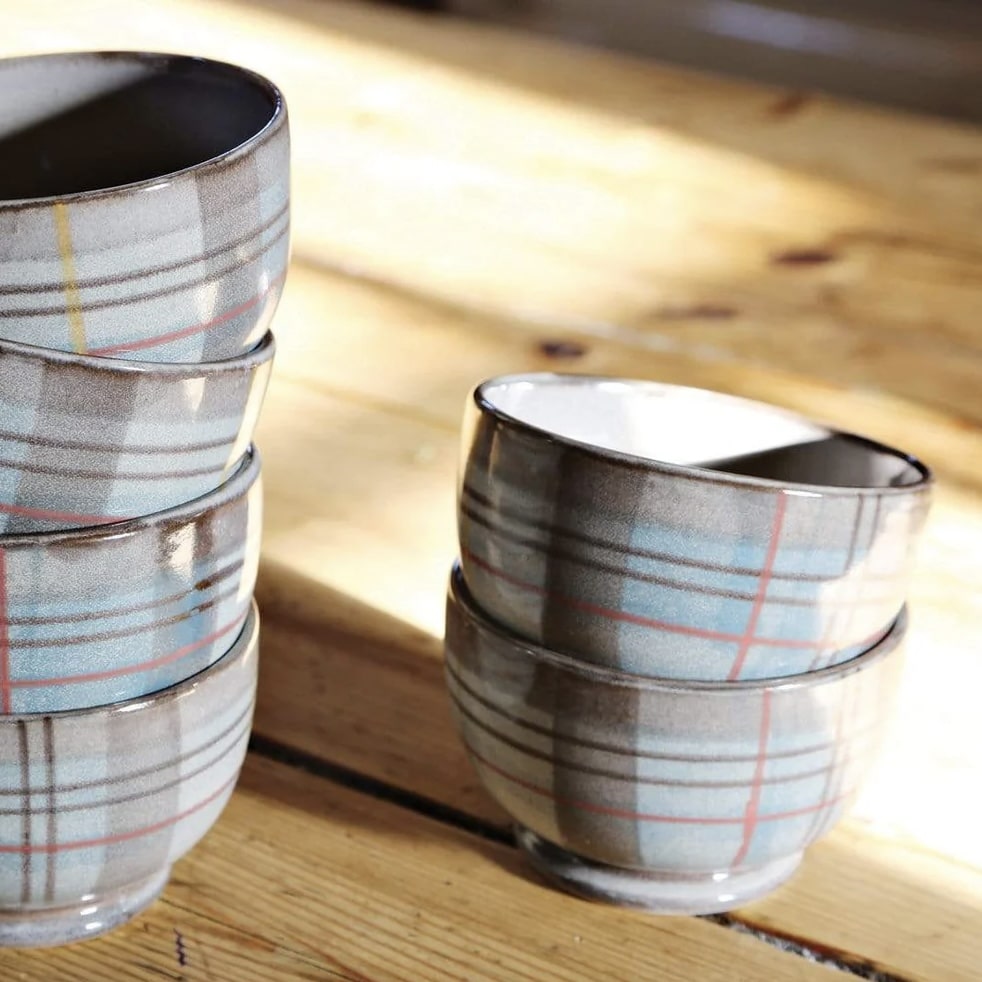 ANTA Isobel Anderson Small Bowls stacked on a wooden surface in dappled light – handmade tartan stoneware from Scotland