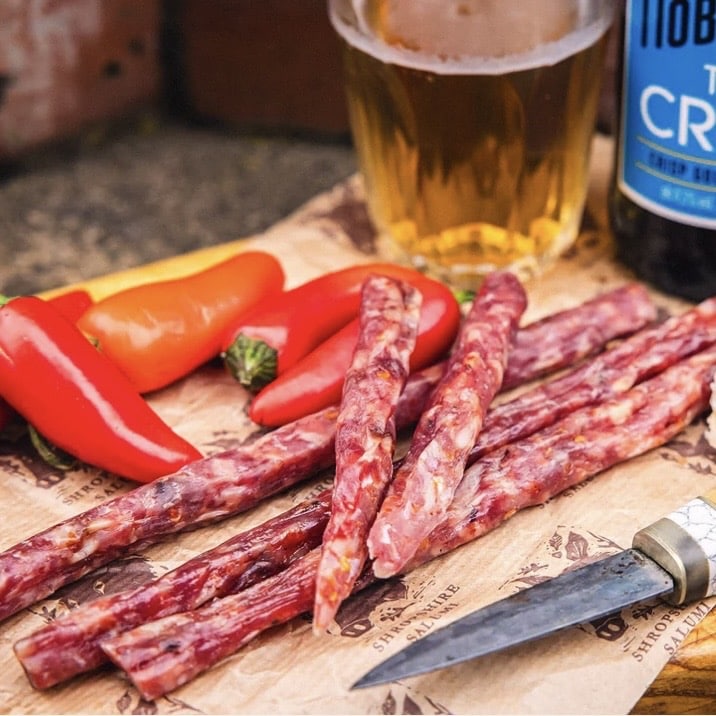 Shropshire Salumi Hunters Beer Sticks with chilli peppers and Hobson's Town Crier ale on a wooden board
