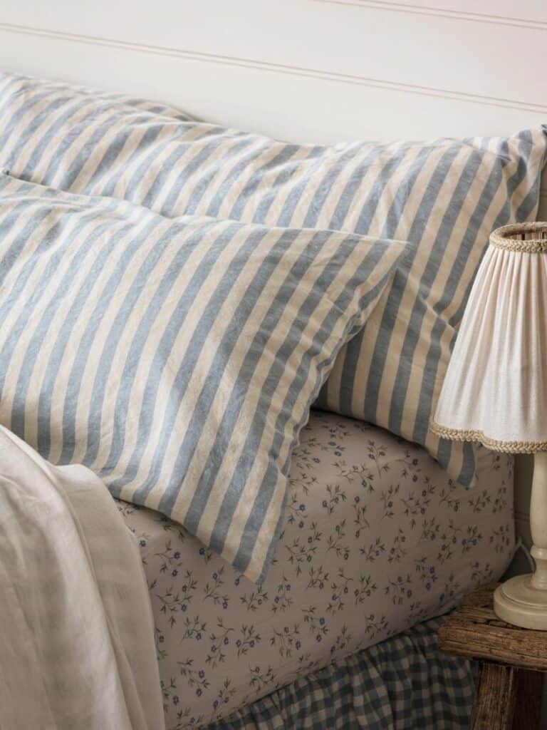 striped linen pillowcases blue and white cottage bedroom bedding layered textures cosy cottage bedroom decor