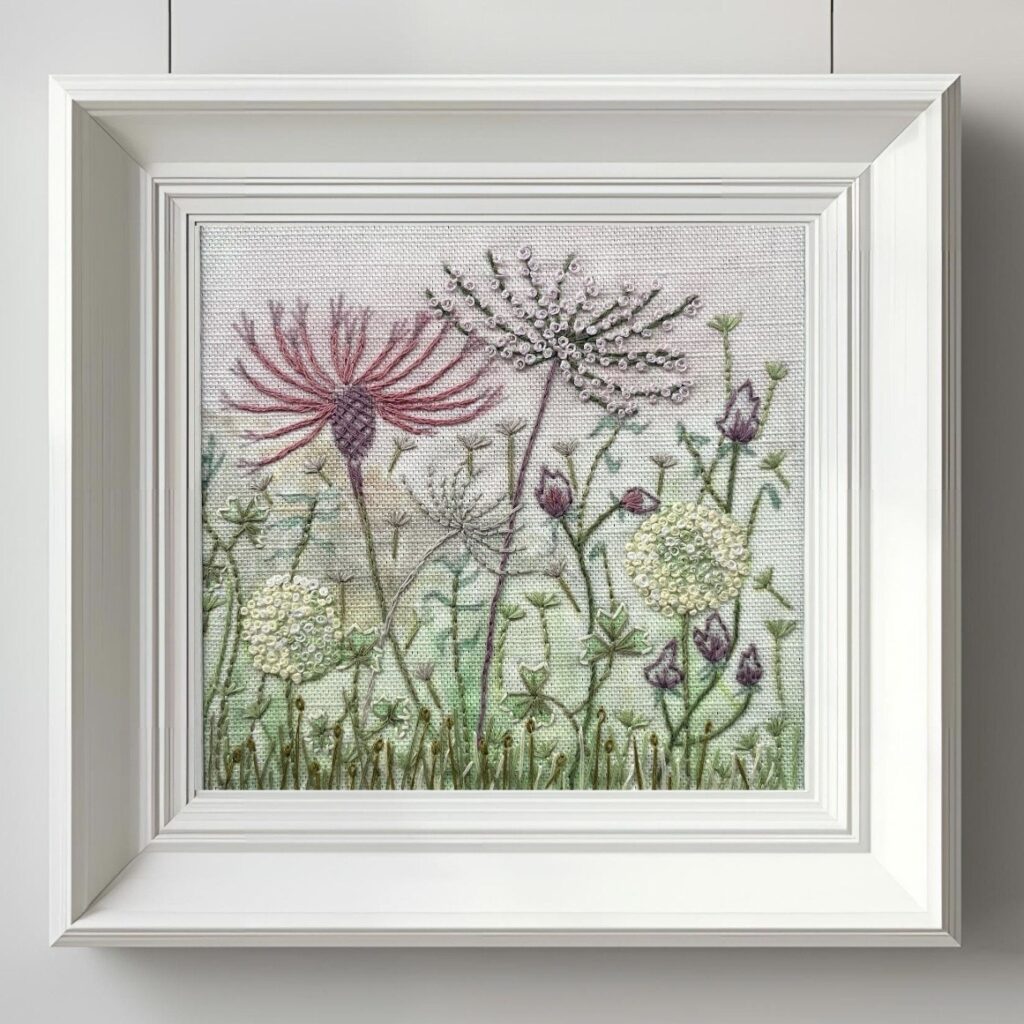 Framed botanical wildflower artwork adding texture to cottage bedroom decor