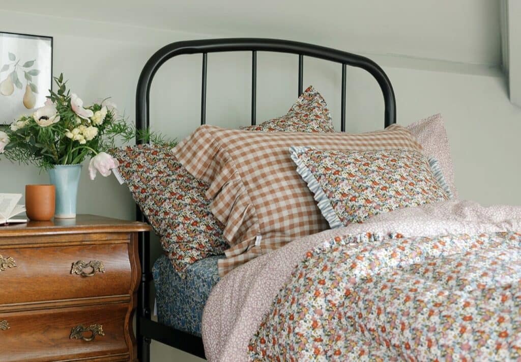 cottage bedroom decor with floral bedding and gingham ruffle pillowcases layered textiles cosy cottage bedroom ideas