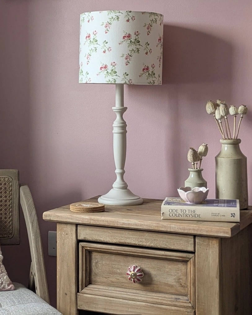 floral lampshade bedside lamp in cottage bedroom decor with soft pink wall and wooden nightstand