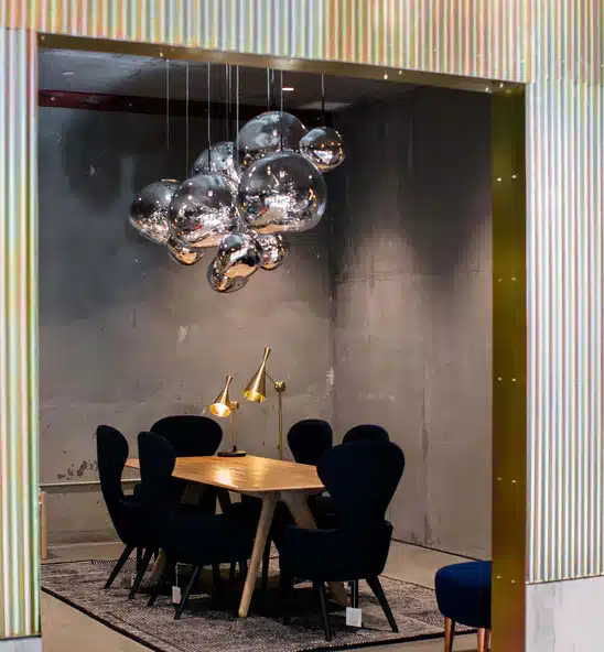 Tom Dixon Melt smoked globe cluster pendant over a dining table in a dark industrial dining room