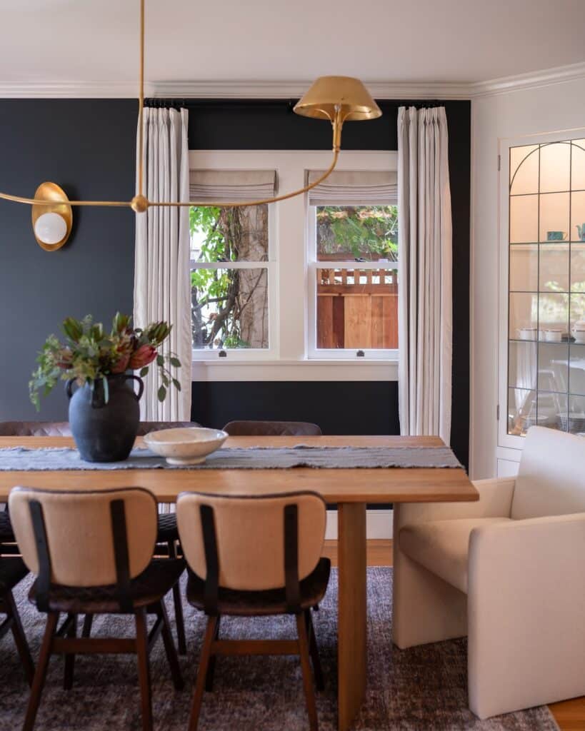 dark blue-grey dining room in Farrow and Ball Railings with brass pendant light and wall sconce
