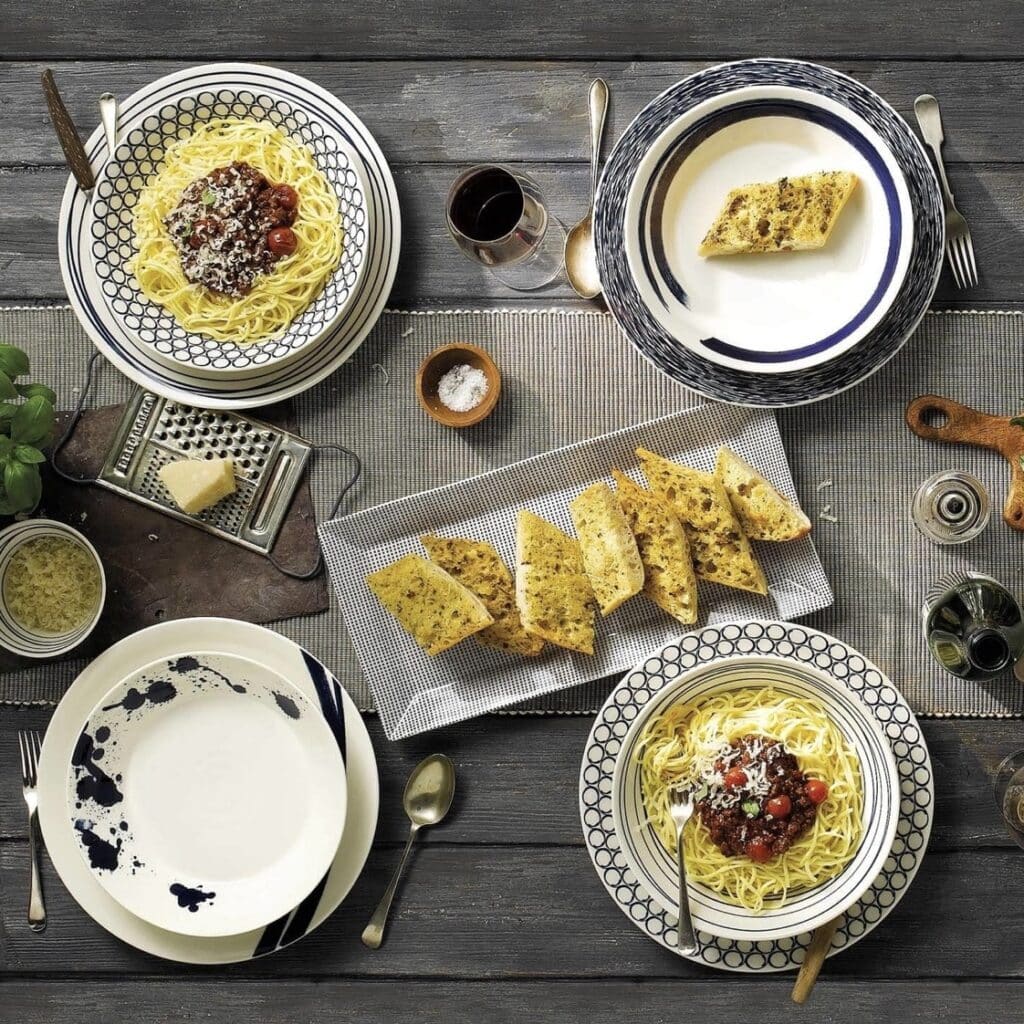 Royal Doulton Pacific Blue pasta bowls and mixed pattern plates styled with pasta and garlic bread on a rustic wood dining table