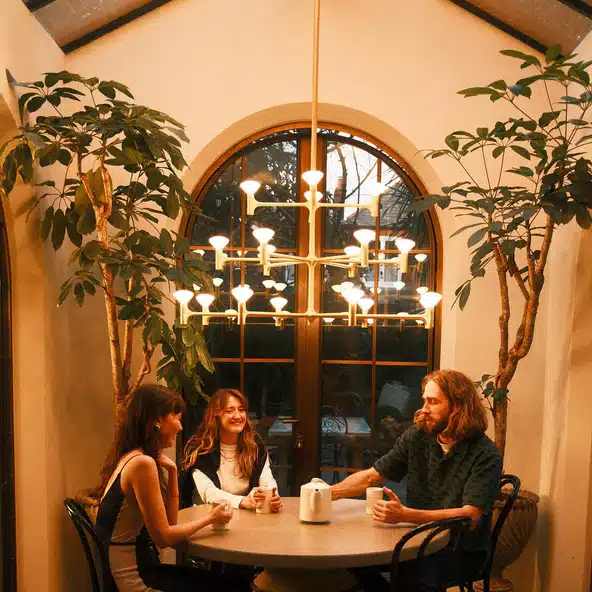 brass Tala Root chandelier over a round dining table in a warm arched dining room