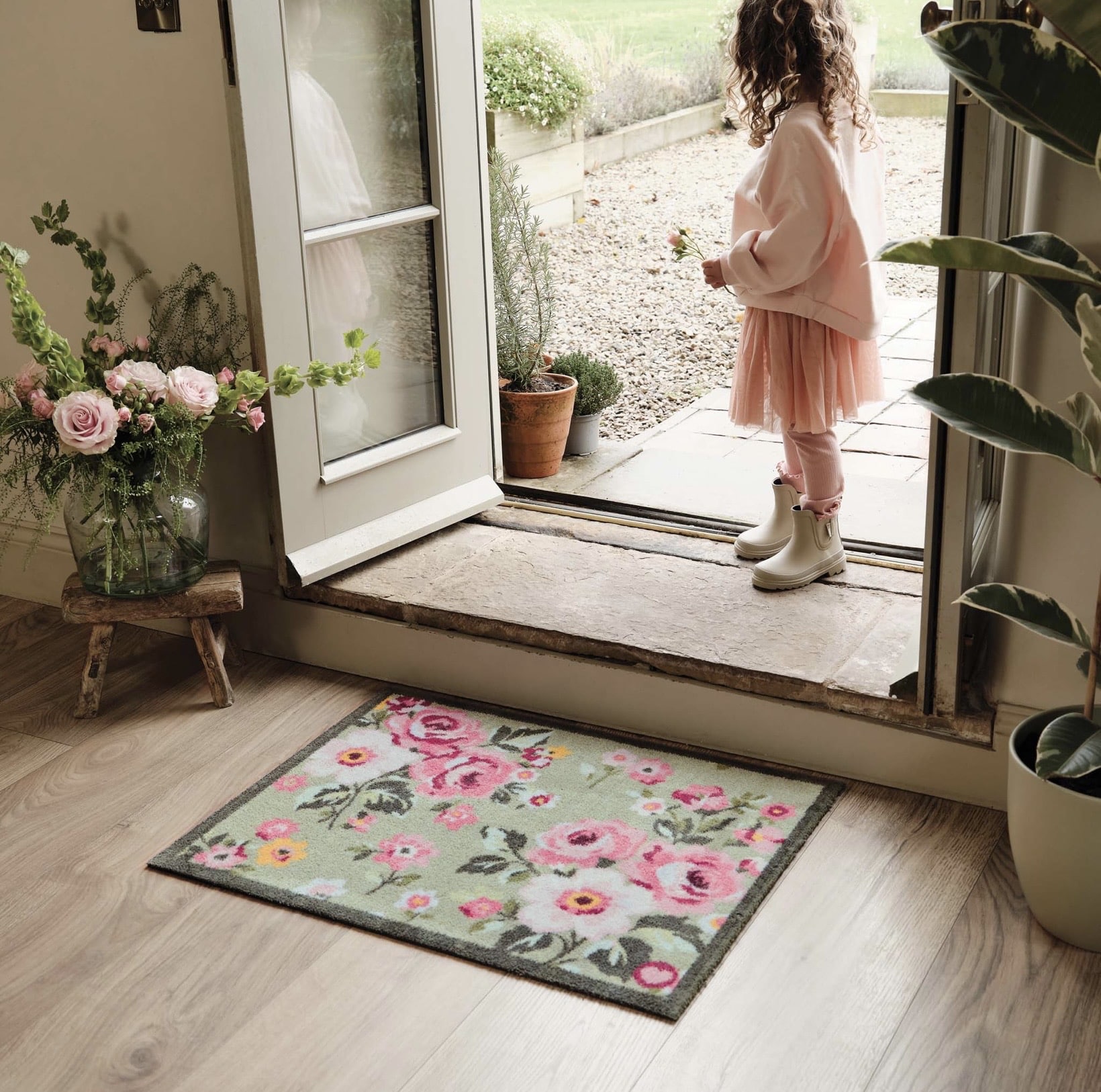 Country Rose Floral washable doormat by Hug Rug styled at front door with pink roses and terracotta pots
