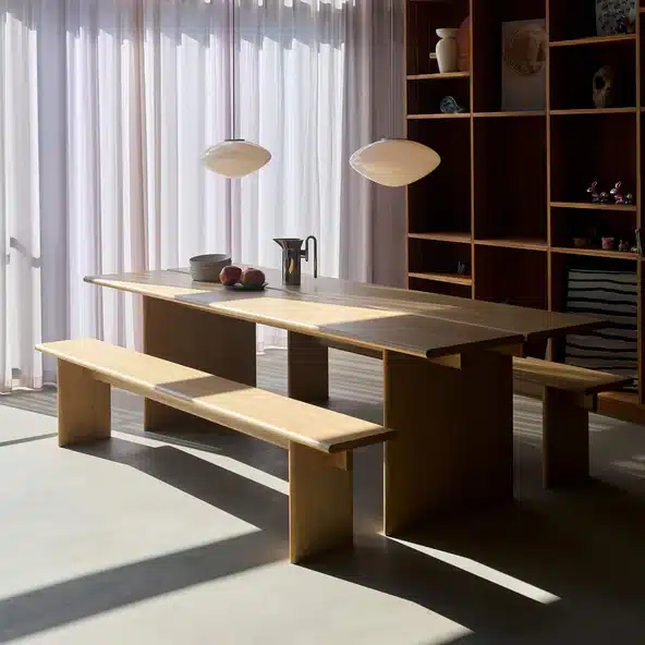 Japandi dining room with &Tradition OS1 Ita dining table in pale oak with slab benches, ceramic vessels and pendant lights against sheer curtains