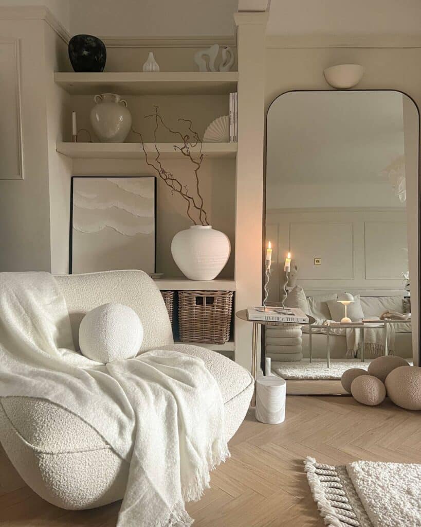 Japandi living room with boucle armchair, arched floor mirror, built-in shelving styled with white ceramics and herringbone oak floor painted in Farrow and Ball School House White
