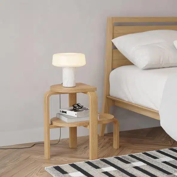 Case Furniture Altura step stool in bentwood oak beside an oak bed frame on herringbone parquet floor with white mushroom table lamp