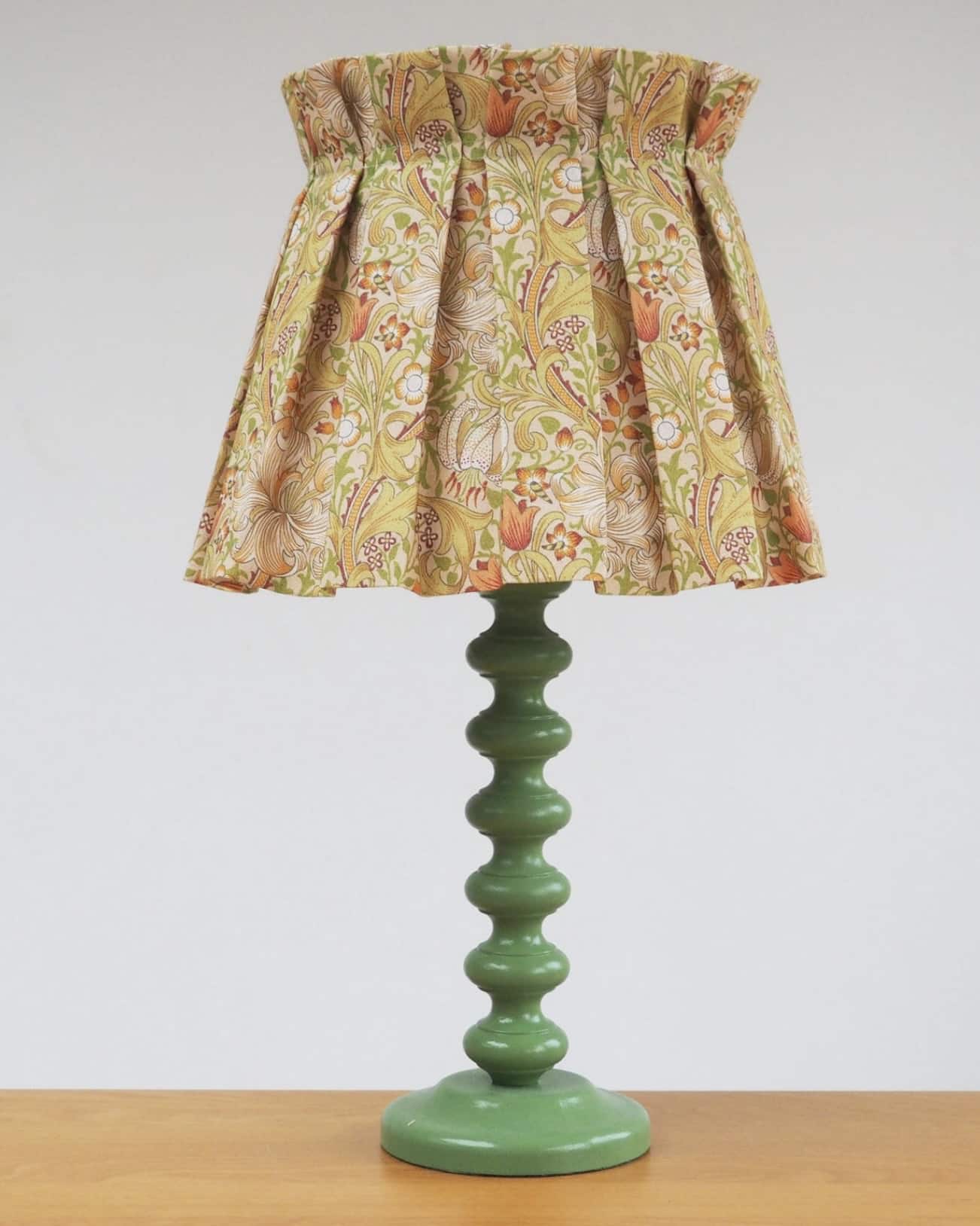 Handmade William Morris box pleat lampshade on green bobbin base by laampshades