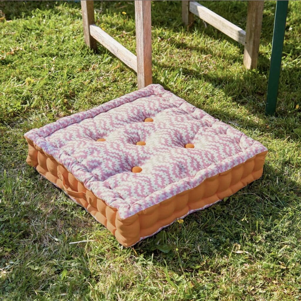 Pink and orange outdoor garden floor cushion in geometric wave print with button detail, Land and Shore Sperrin range