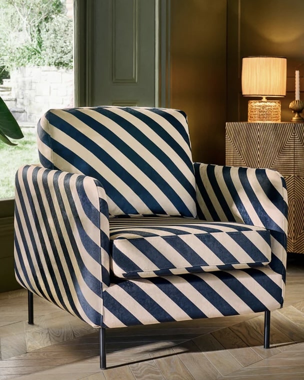 Black and sand striped accent chair with slim black legs in a contemporary living room.