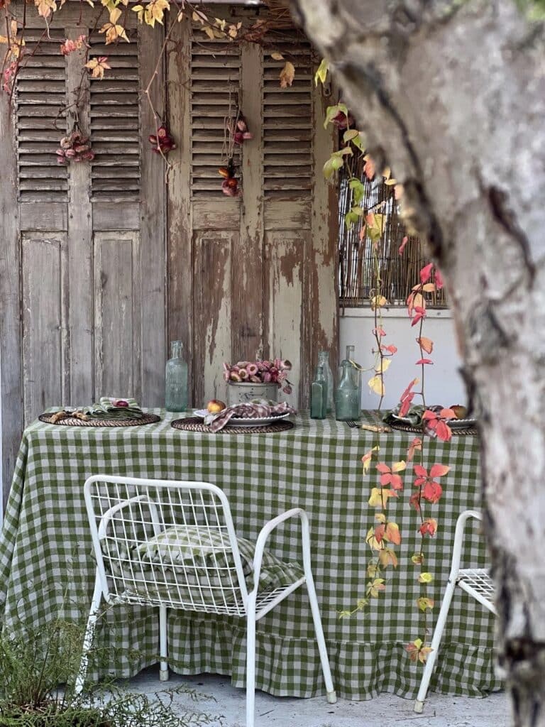 Green gingham linen tablecloth on an outdoor dining table — outdoor dining table decor ideas