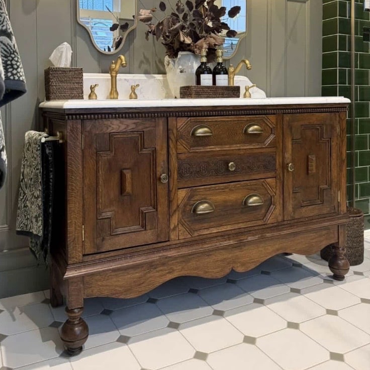 double oak vanity unit with brass taps on marble top