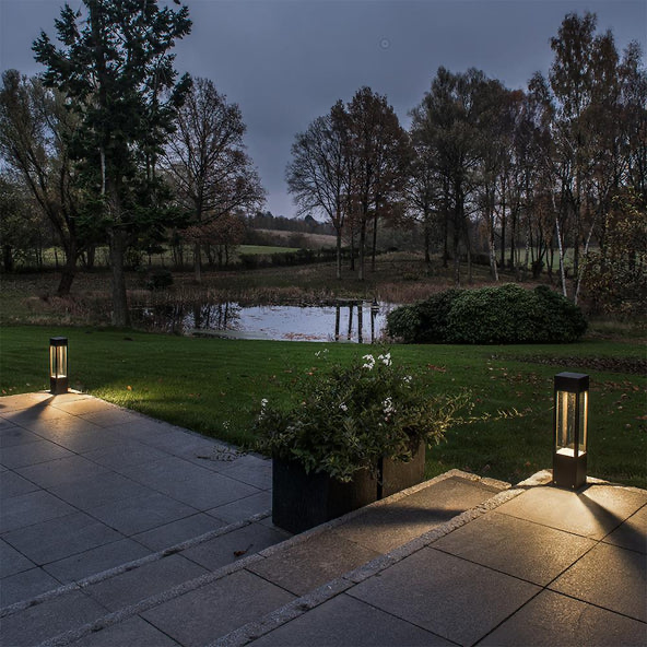Bollard lights lining a stone garden path at dusk, garden path ideas