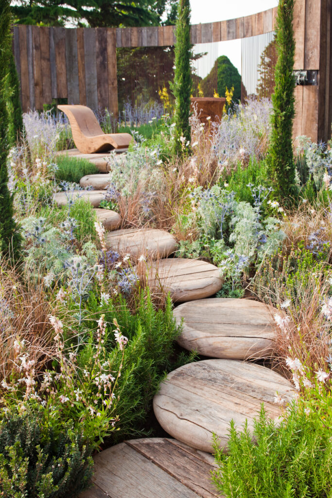 Curved timber stepping stone path through naturalistic planting, garden path ideas