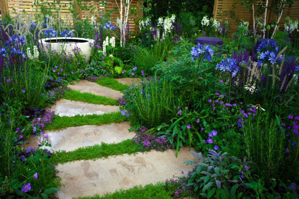 Large flat stepping stones set into grass and border planting, garden path ideas
