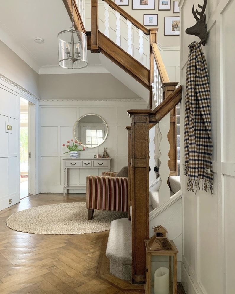 Period hallway wainscoting with timber staircase and herringbone parquet floor
