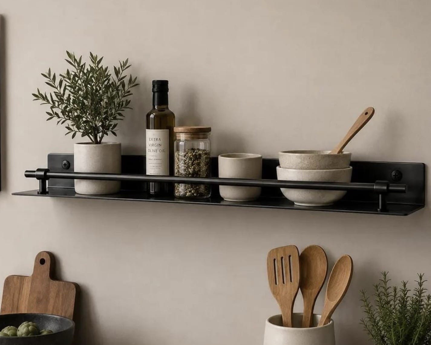 Black metal floating shelf with a front guard rail holding olive oil, a spice jar and stoneware bowls, kitchen floating shelves