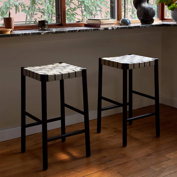 Two backless stools with woven natural webbing seats on black lacquered oak frames