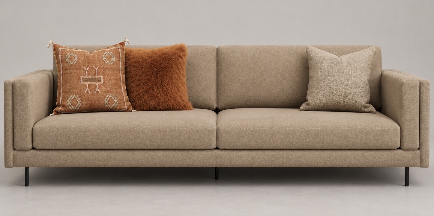 Beige sofa styled with orange, zig-zag and neutral cushions