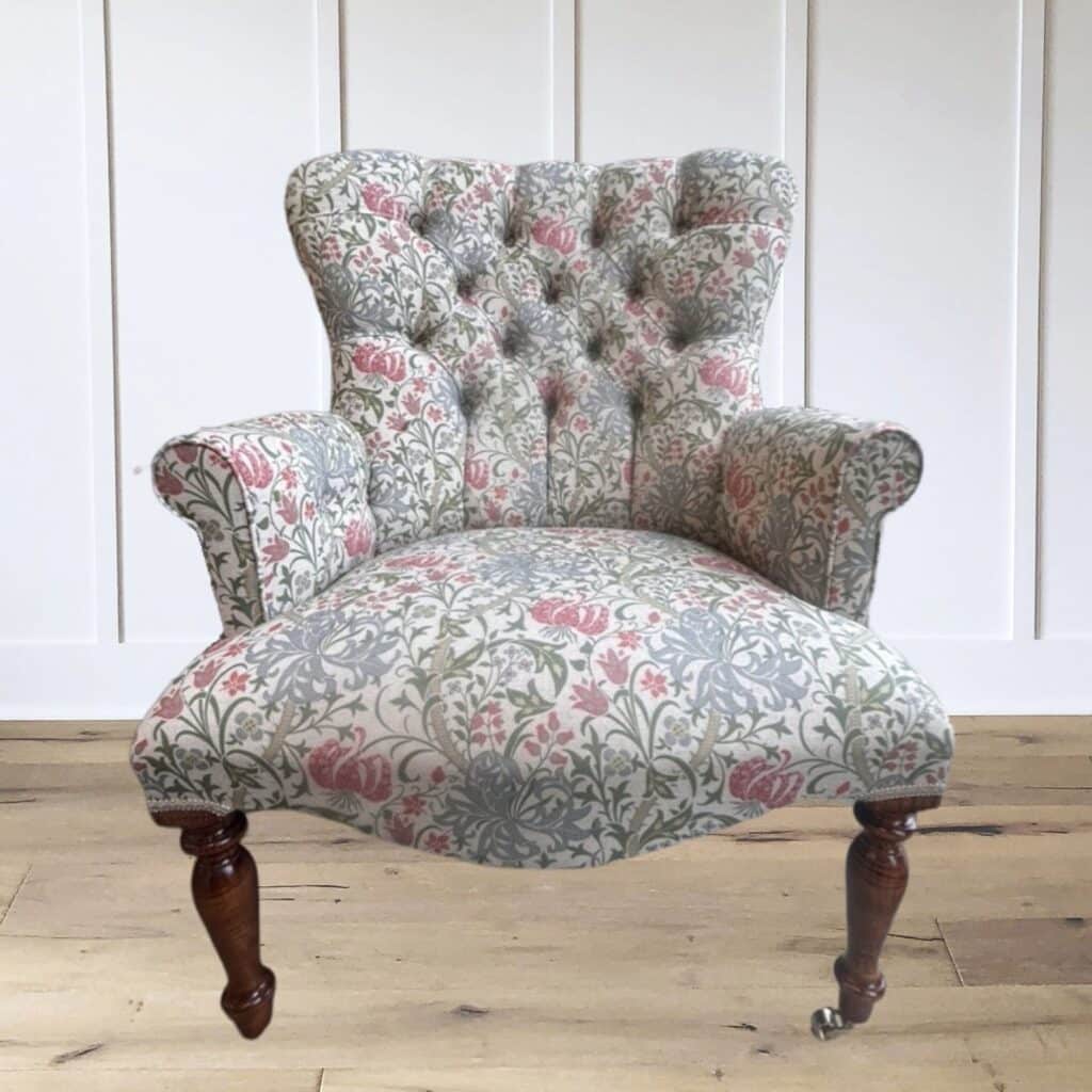 Deep-buttoned floral accent chair in a William Morris-style pink and sage print with turned wooden legs