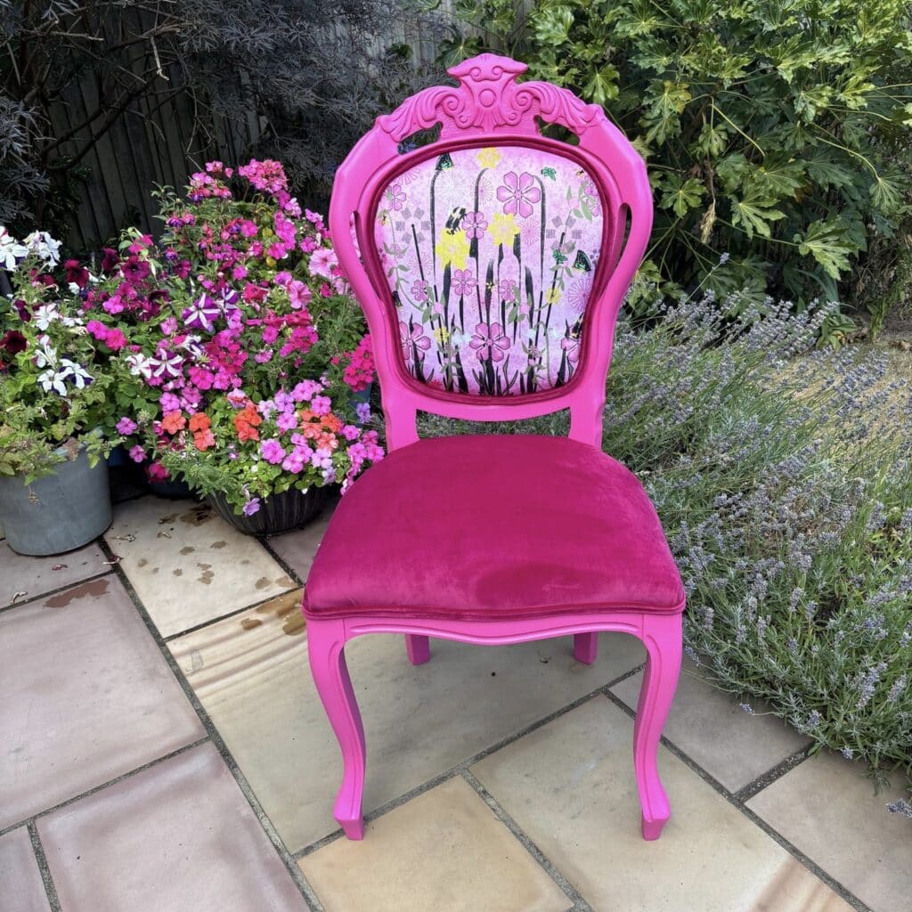 Hot pink painted vintage accent chair with a hand-painted floral back panel and pink velvet seat