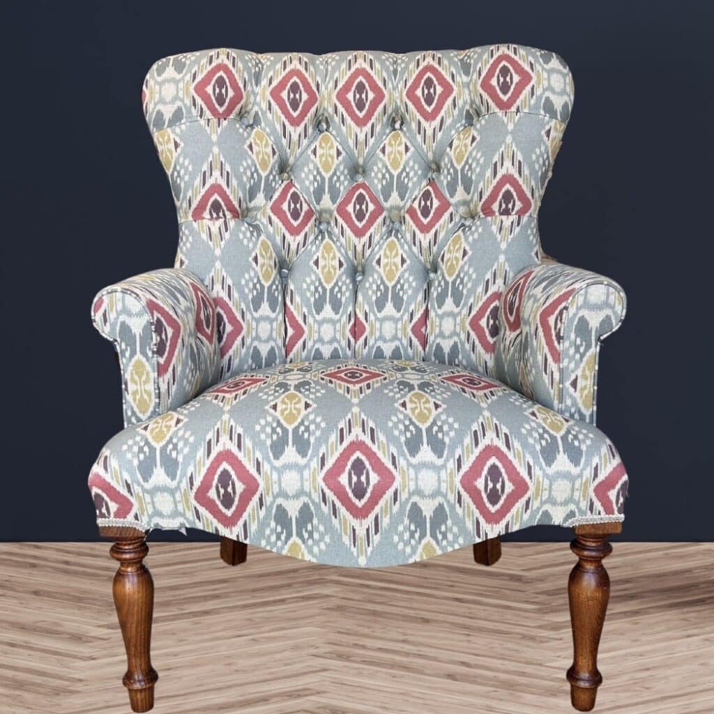 Deep-buttoned ikat accent armchair in blue, red and mustard diamond print linen with turned wooden legs